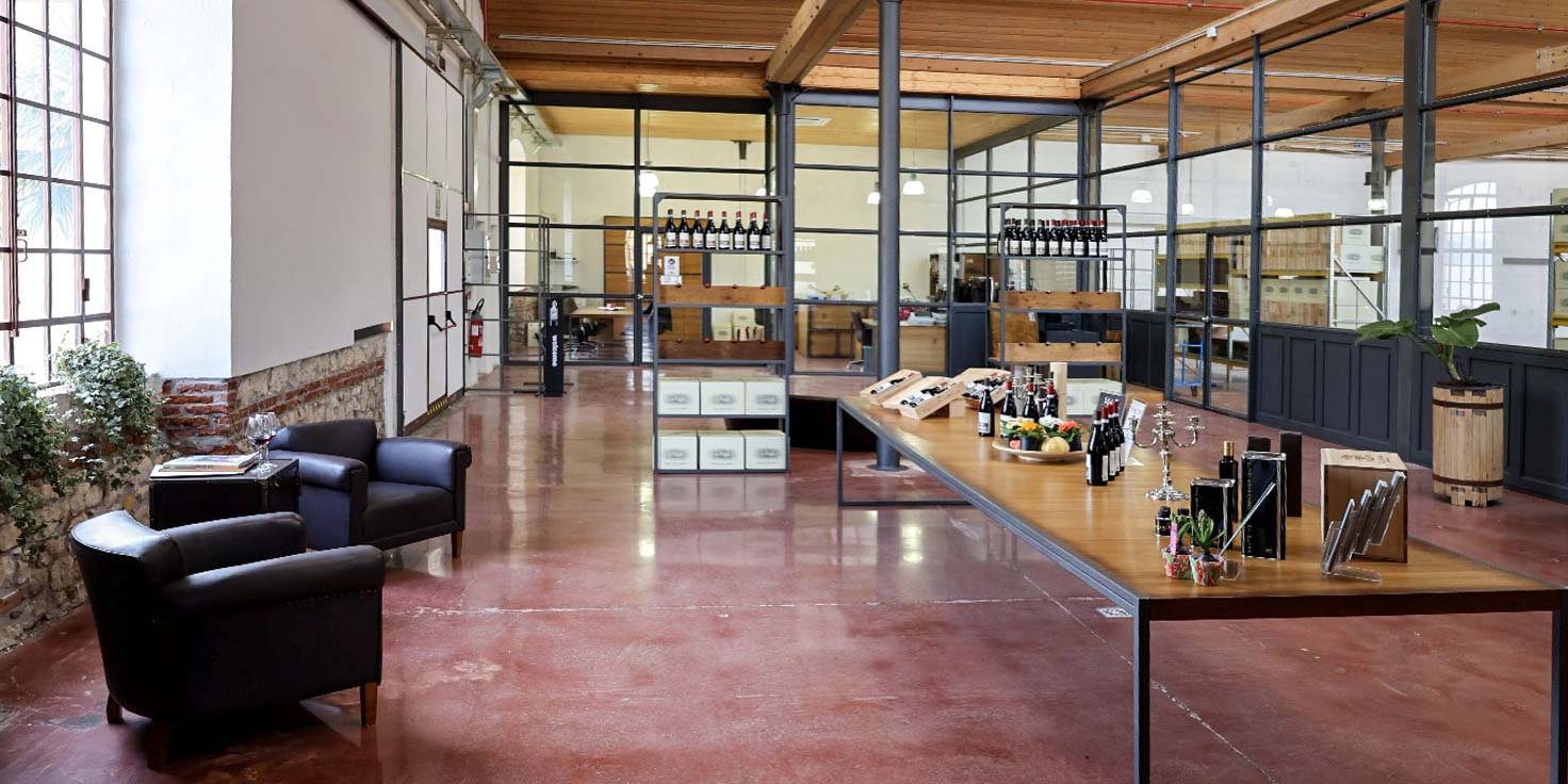 Foto all'interno dello shop con bottiglie in esposizio e e tavolo imbandito con prodotti locali